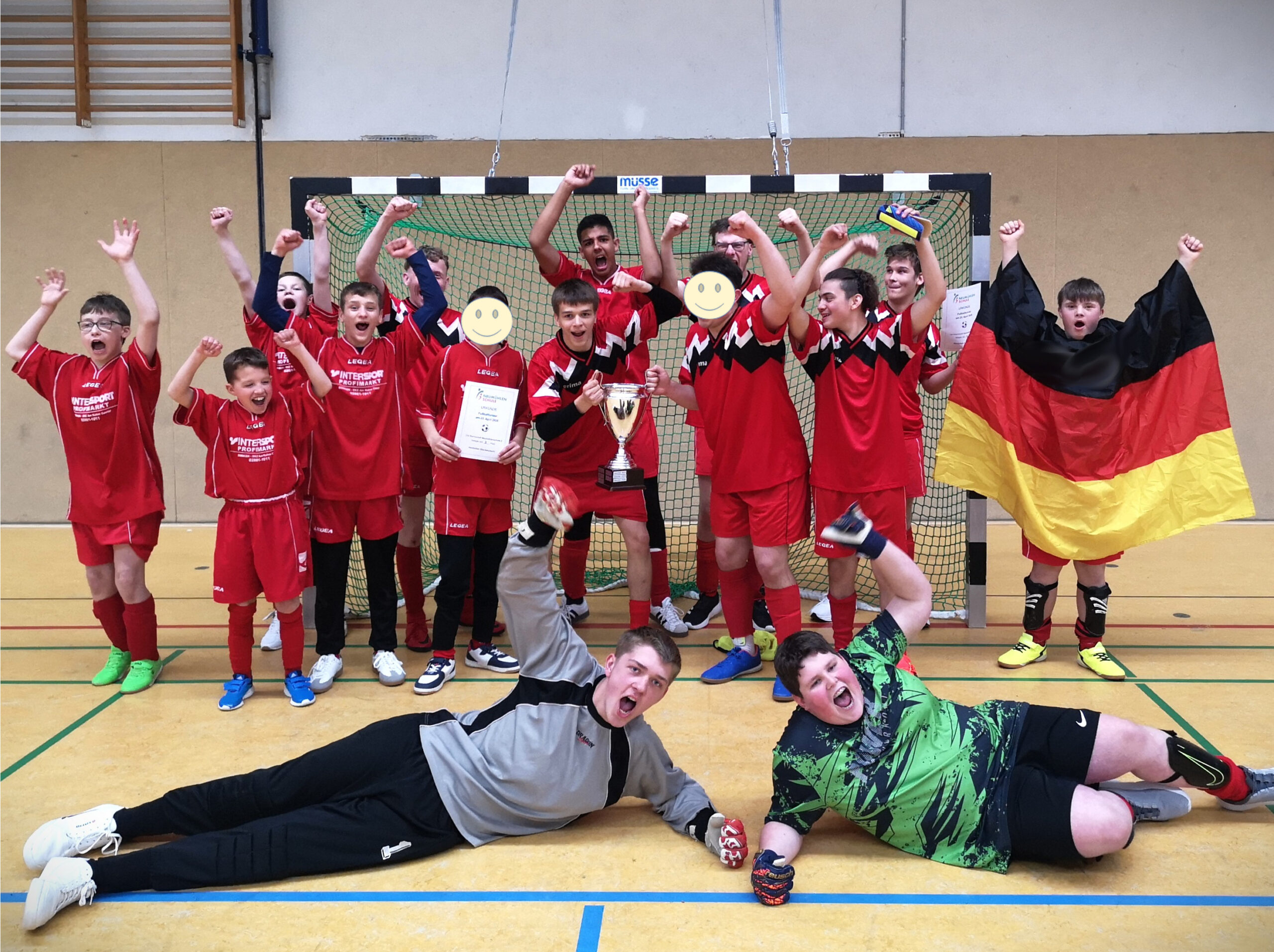 Die siegreiche Mannschaft des Fußballturniers jubelt mit Pokal und Urkunde.